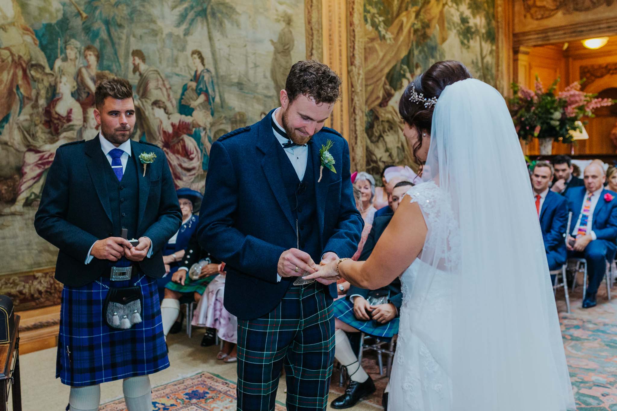 groom-putting-wedding-ring-brides-finger-dumfries-house