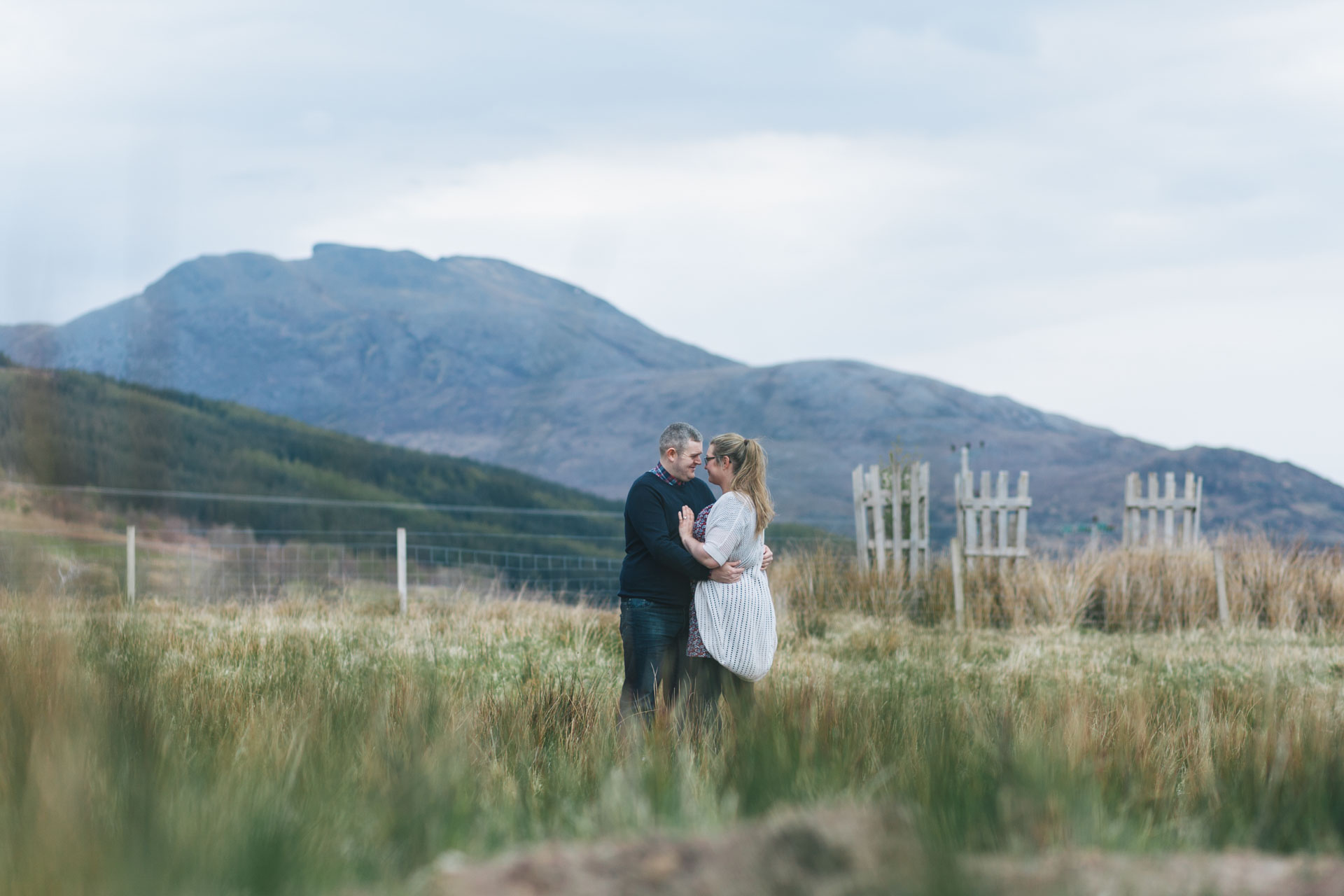 woman-man-embracing-couples-shoot-in-lochcarron-field
