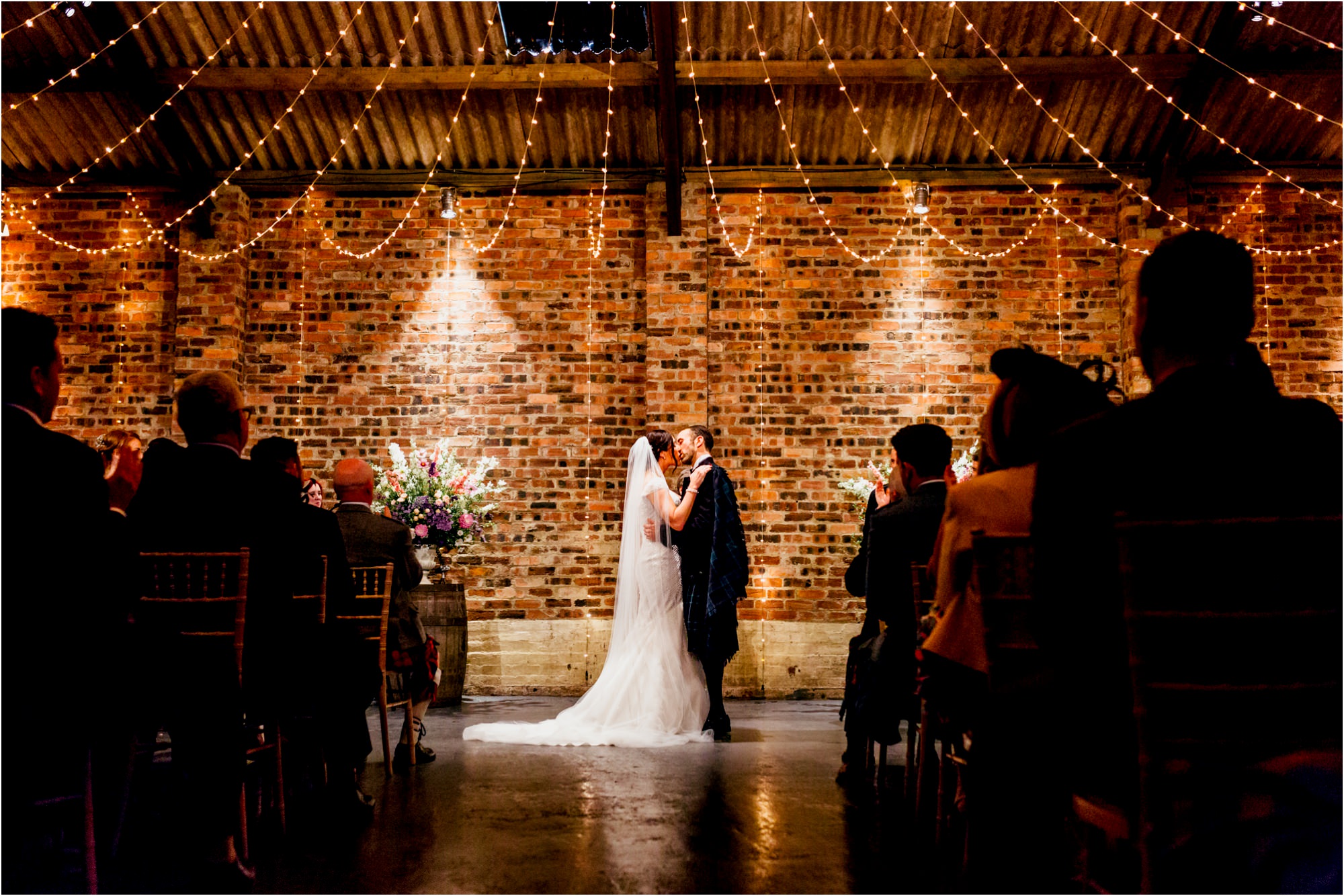 bride-groom-first-kiss-under-fairy-lights-kinkell-byre