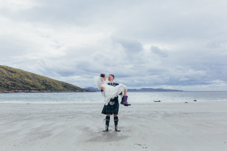 groom-carrying-bride-in-arms-lochnell-beach