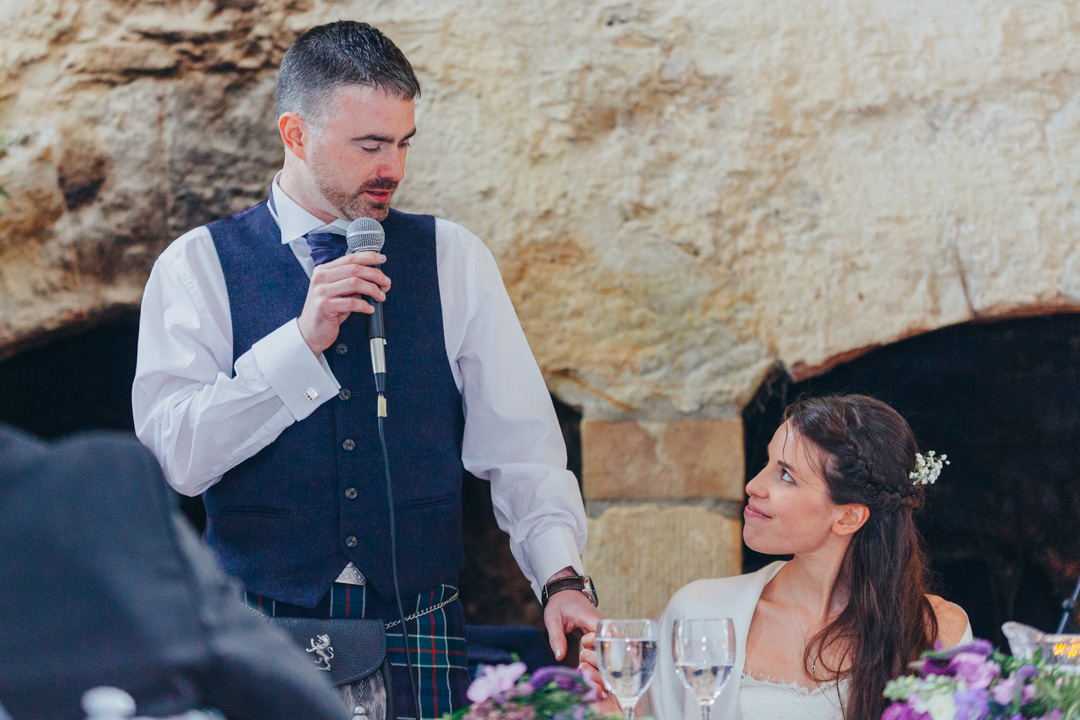 wife-holding-grooms-hand-during-speech