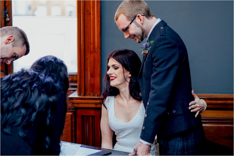 bride-smiling-as-witnesses-sign-register