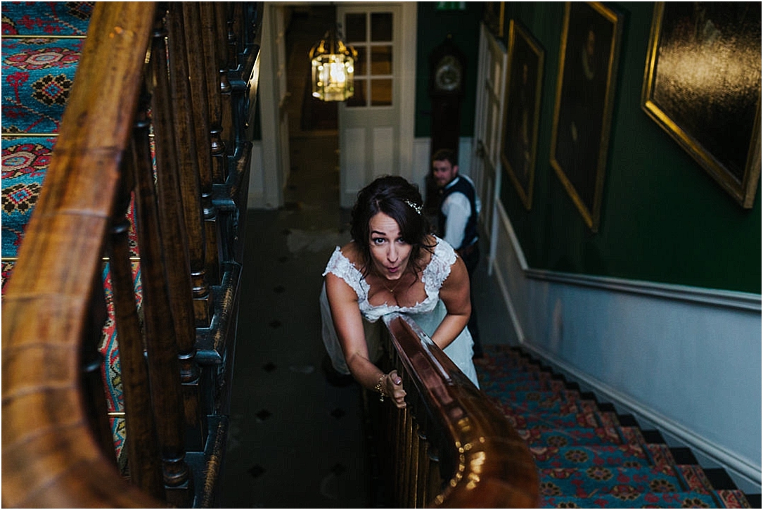 bride-sliding-down-bannister-on-wedding-day