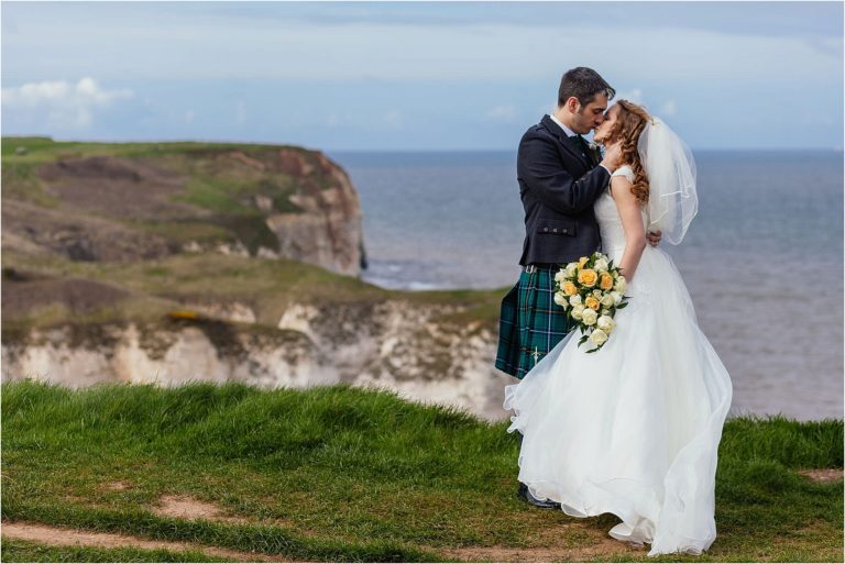 bride groom kissing on flamborough cliffs