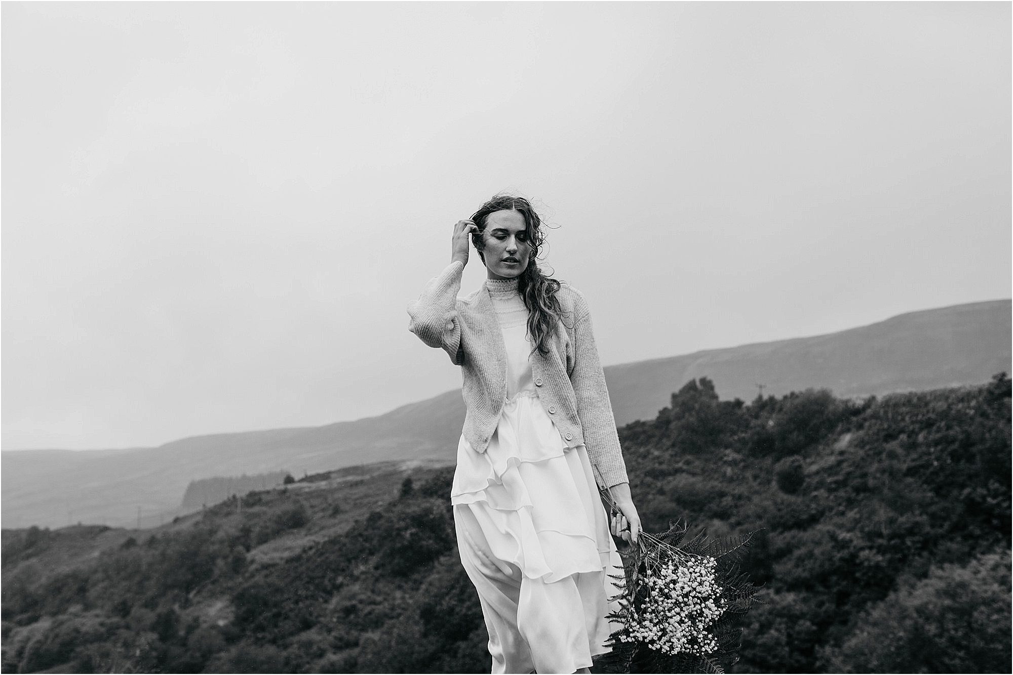 black-and-white-photo-of-bride-standing-in-hilltop