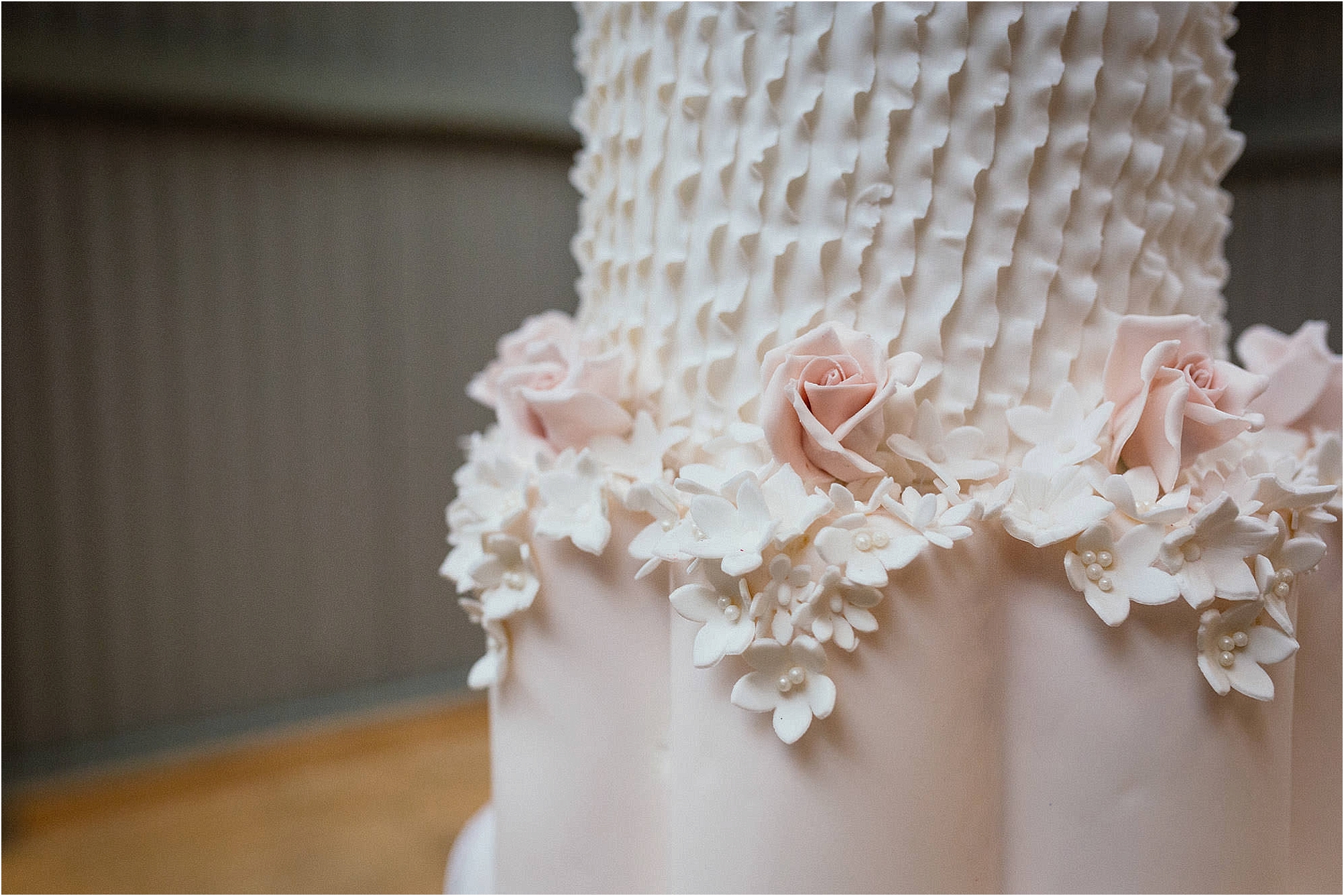 iced-blush-pink-roses-on-wedding-cake-with-white-ruffles