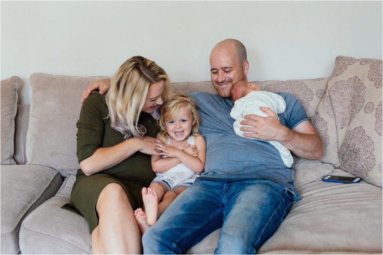 family-sitting-together-on-sofa