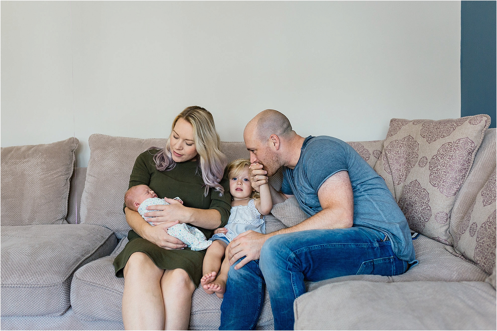 family-sitting-together-dad-kissing-daughters-hand