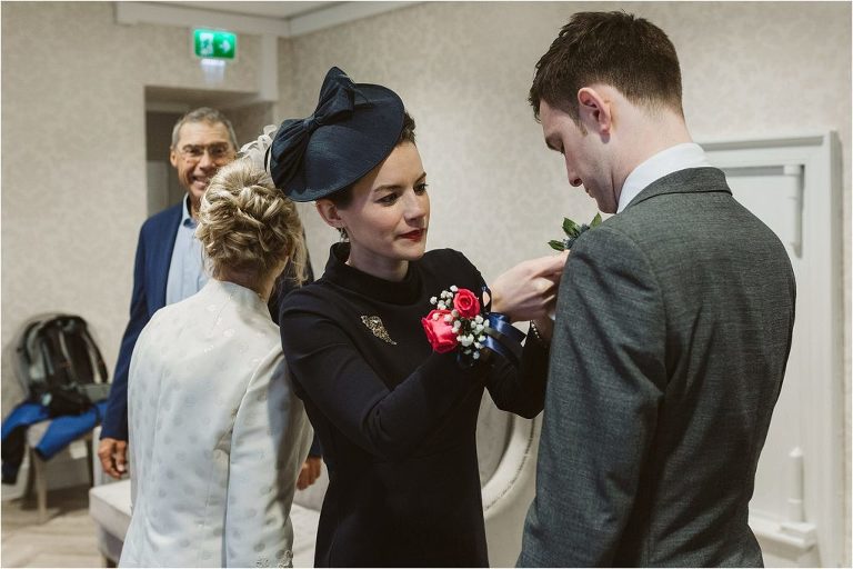 guest-adjusts-boutonniere-of another-guest