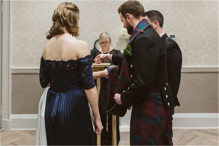 best-man-and-bridesmaid-help-bride-groom-with-hand-fasting