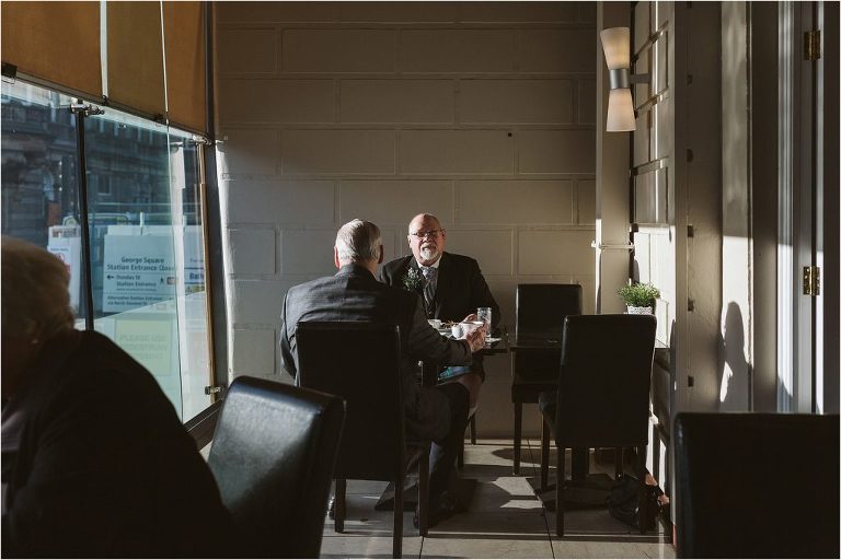 groom-sitting-in-window-seat-with-father