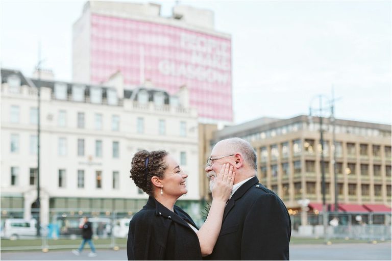 bride-touching-husbands-face-in-front-of-people-make-glasgow-sign