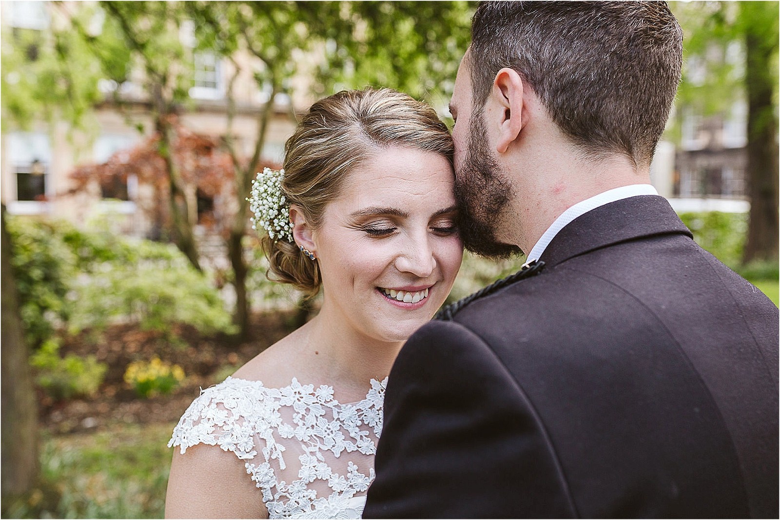 bride-smiles-while-husband-kisses-her
