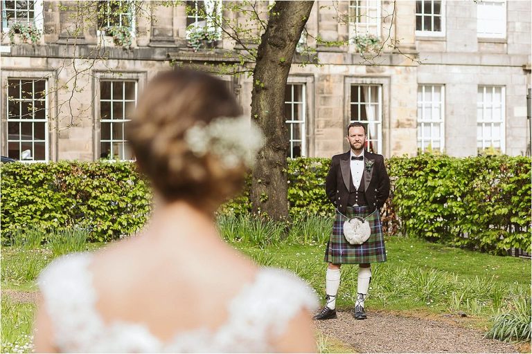 groom-stands-looking-towards-his-wife-who-is-in-the-foreground