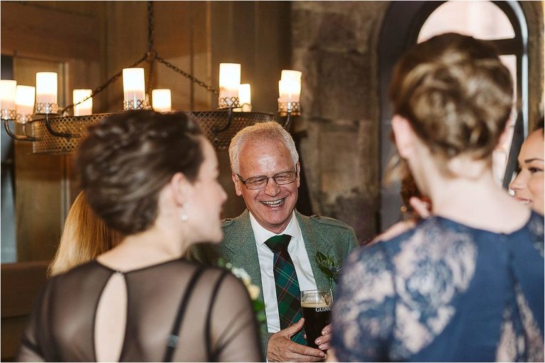father-of-groom-laughs-with-guests