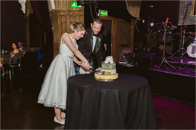 bride-groom-laugh-as-they-try-to-cut-cake-of-cheese