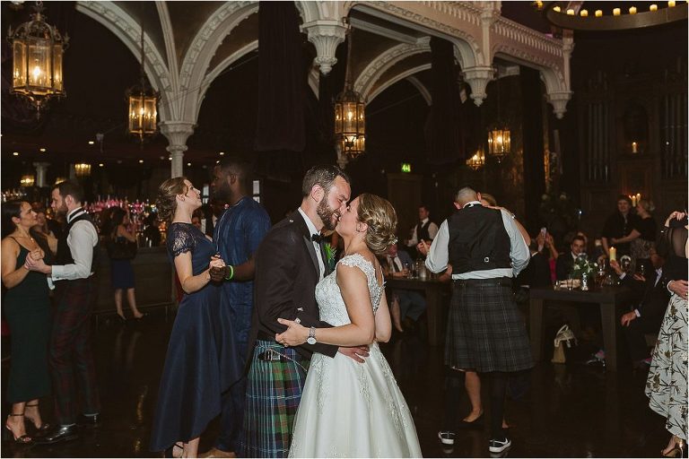 bride-and-groom-share-kiss-as-everyone-else-dances