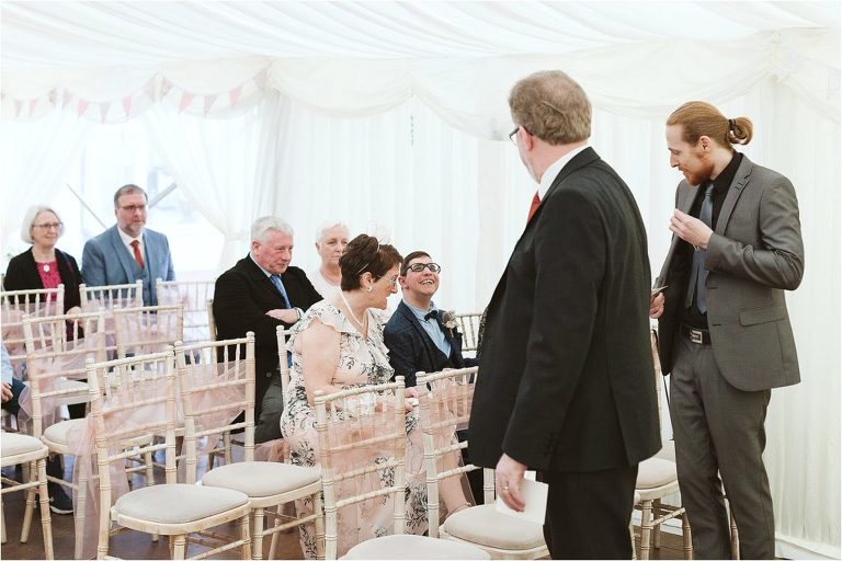 grooms-brother-smiling-at-guests