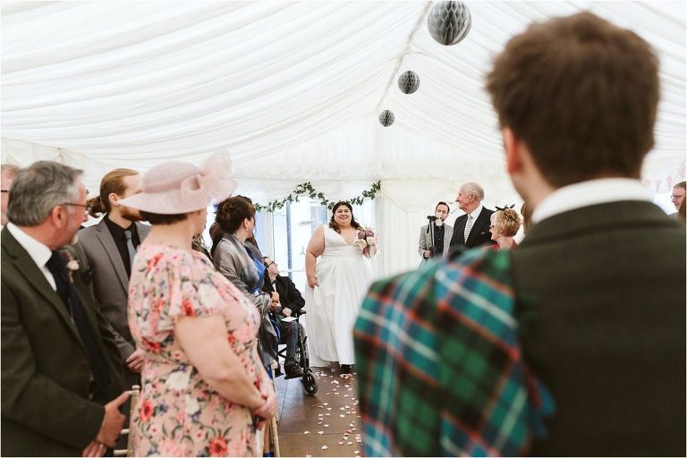 bride-smiling-at-groom-as-she-walks-down-the-aisle