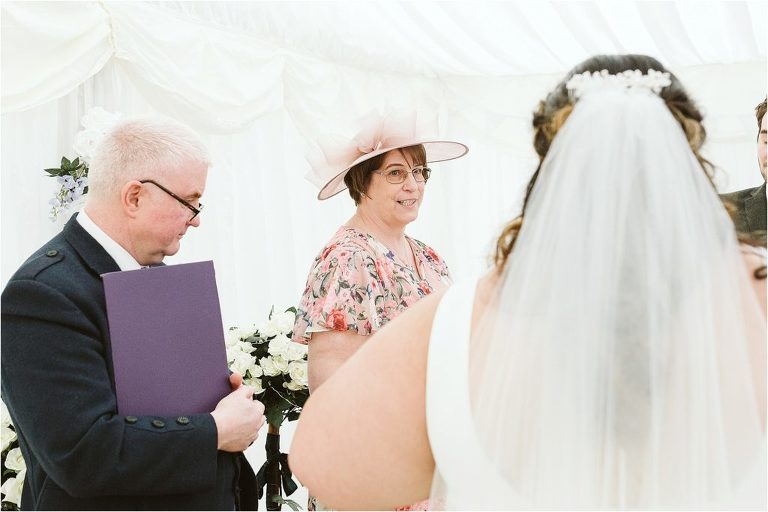 grooms-mum-looks-at-bride-while-giving-a-reading