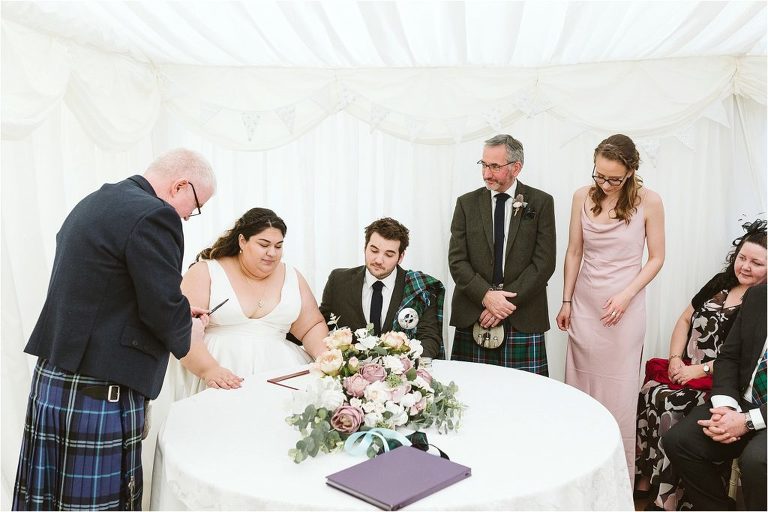 bride-and-groom-sign-register-with-witnesses