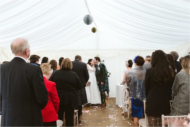 bride-and-groom-kiss-before-walking-down-the-aisle