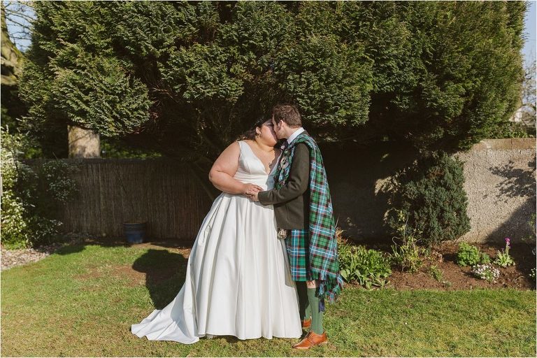 bride-and-groom-kiss-in-garden