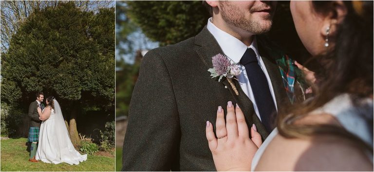 bride-and-groom-pose-in-garden-detail-photo-of-groom-boutonniere