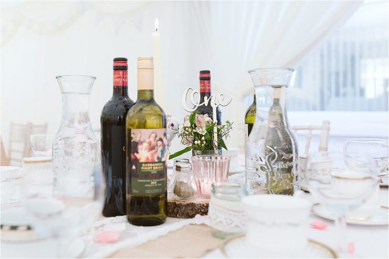 wooden-table-centrepiece-with-red-and-white-wine-fresh-flowers