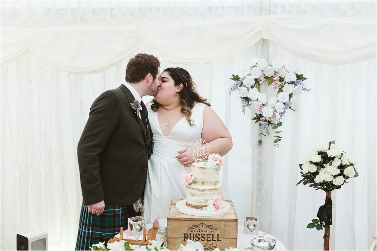 bride-and-groom-kiss-after-cutting-cake