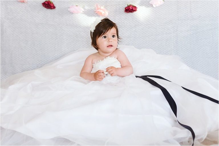 little-girl-sits-in-mums-wedding-dress