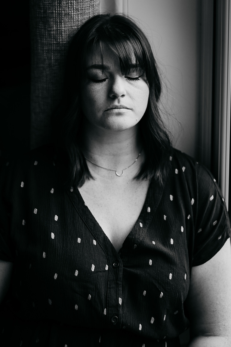 black-and-white-image-of-woman-with-eyes-closed-facing-camera