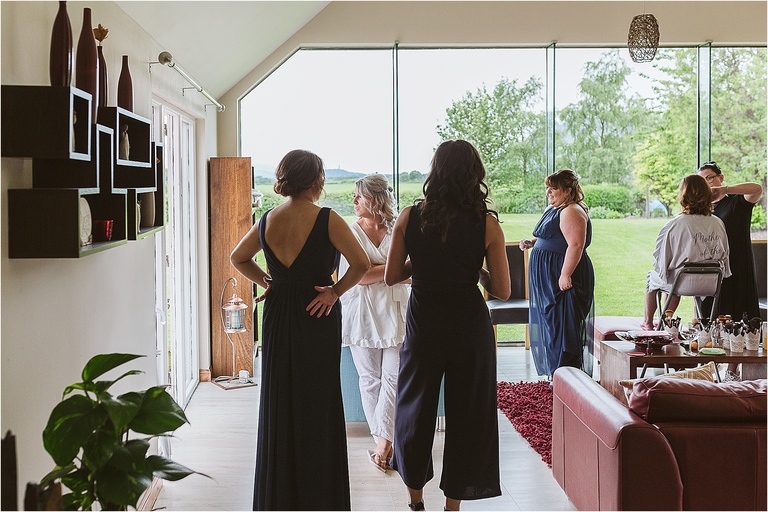 bride-watching-out-of-window-as-guests-arrive