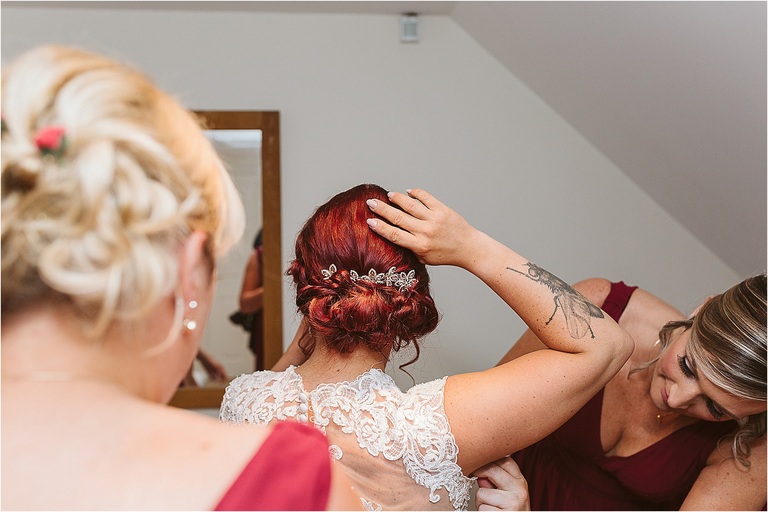 bridesmaids-help-tattooed-bride-in-to-wedding-dress