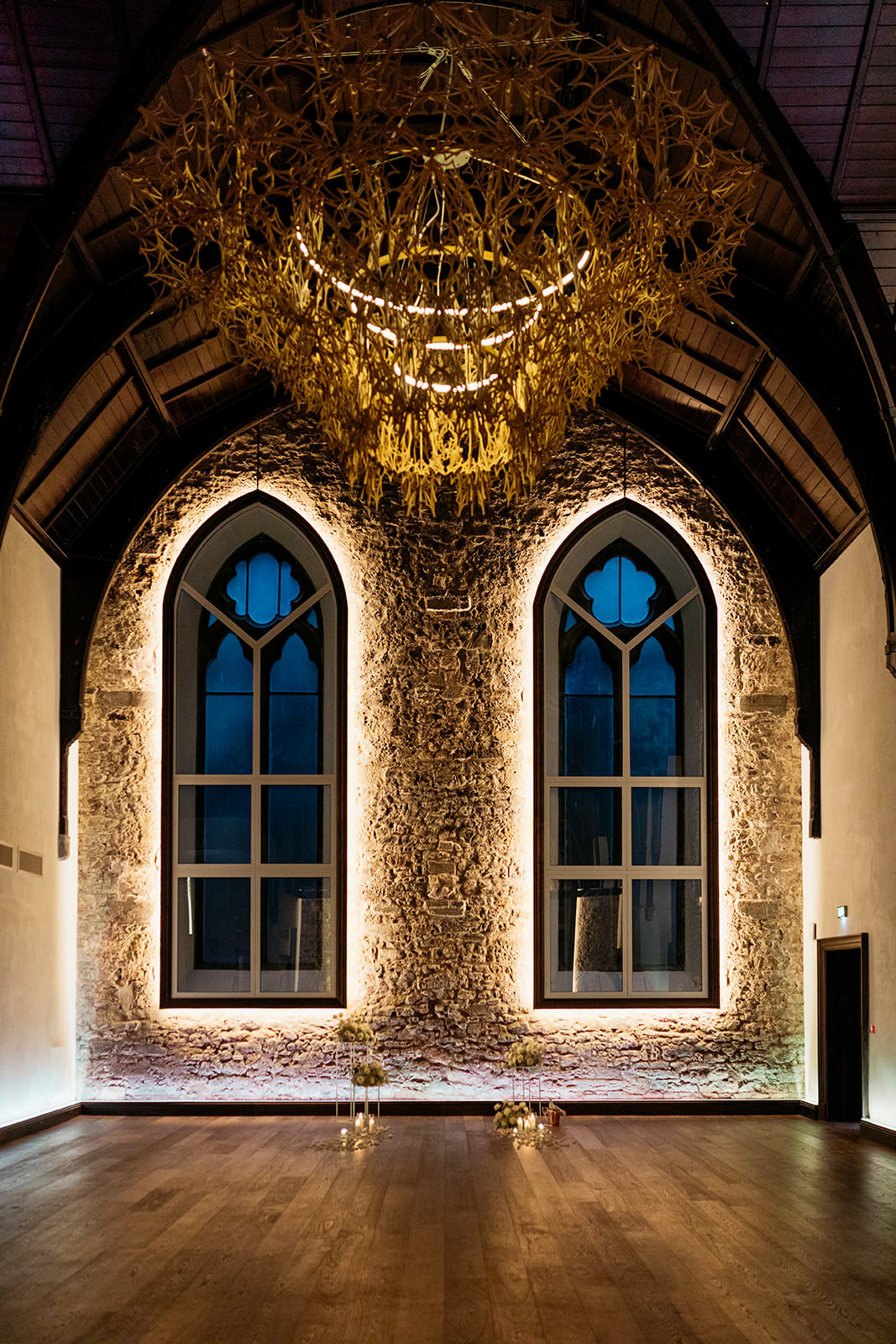 interior-of-greyfriars-hall-virgin-hotel-edinburgh-there-is-an-incredible-intricate-chandelier-which-is-a-focal-point-of-the-room-a-stone-wall-is-a-feature-with-two-arched-windows