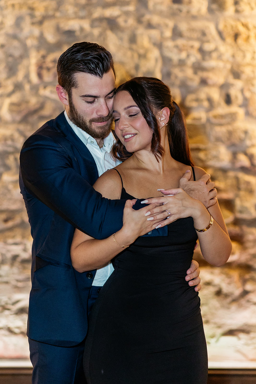 newly-engaged-couple-are-embracing-man-is-holding-his-new-fiance-from-behind-and-their-faces-are-turned-towards-each-other