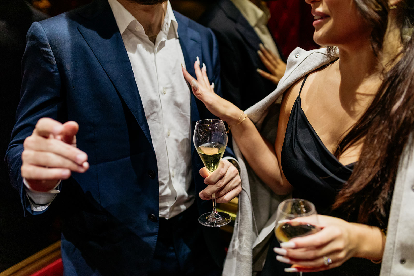 couple-in-lift-woman-is-touching-her-fiances-chest-while-the-drink-champagne