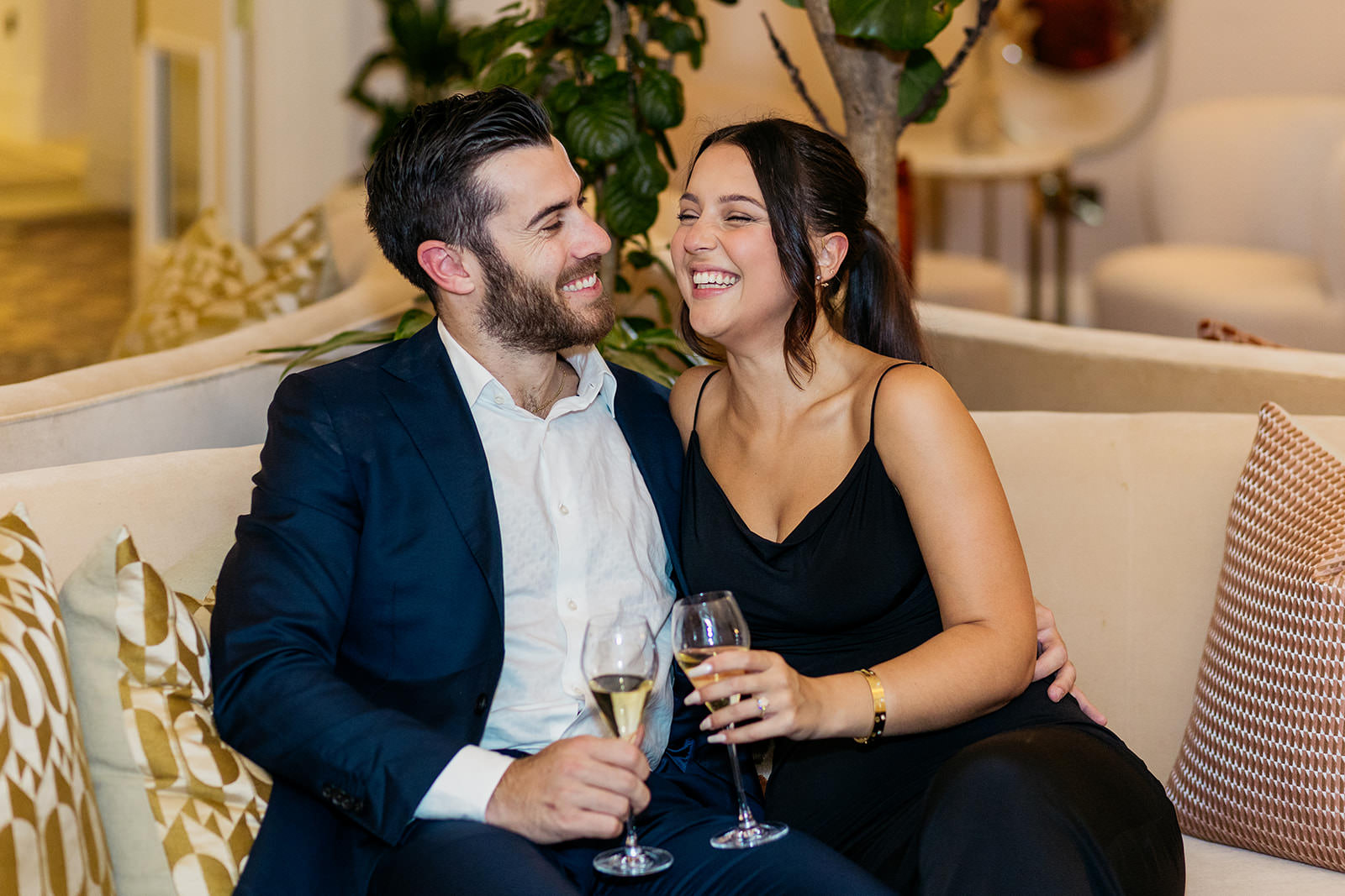 couple-are-laughing-as-they-sip-champagne