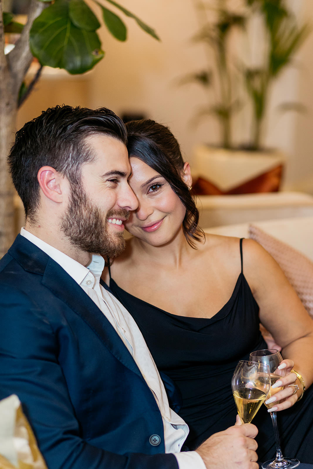 couple-sit-on-sofa-woman-is-looking-in-to-camera-and-smiling