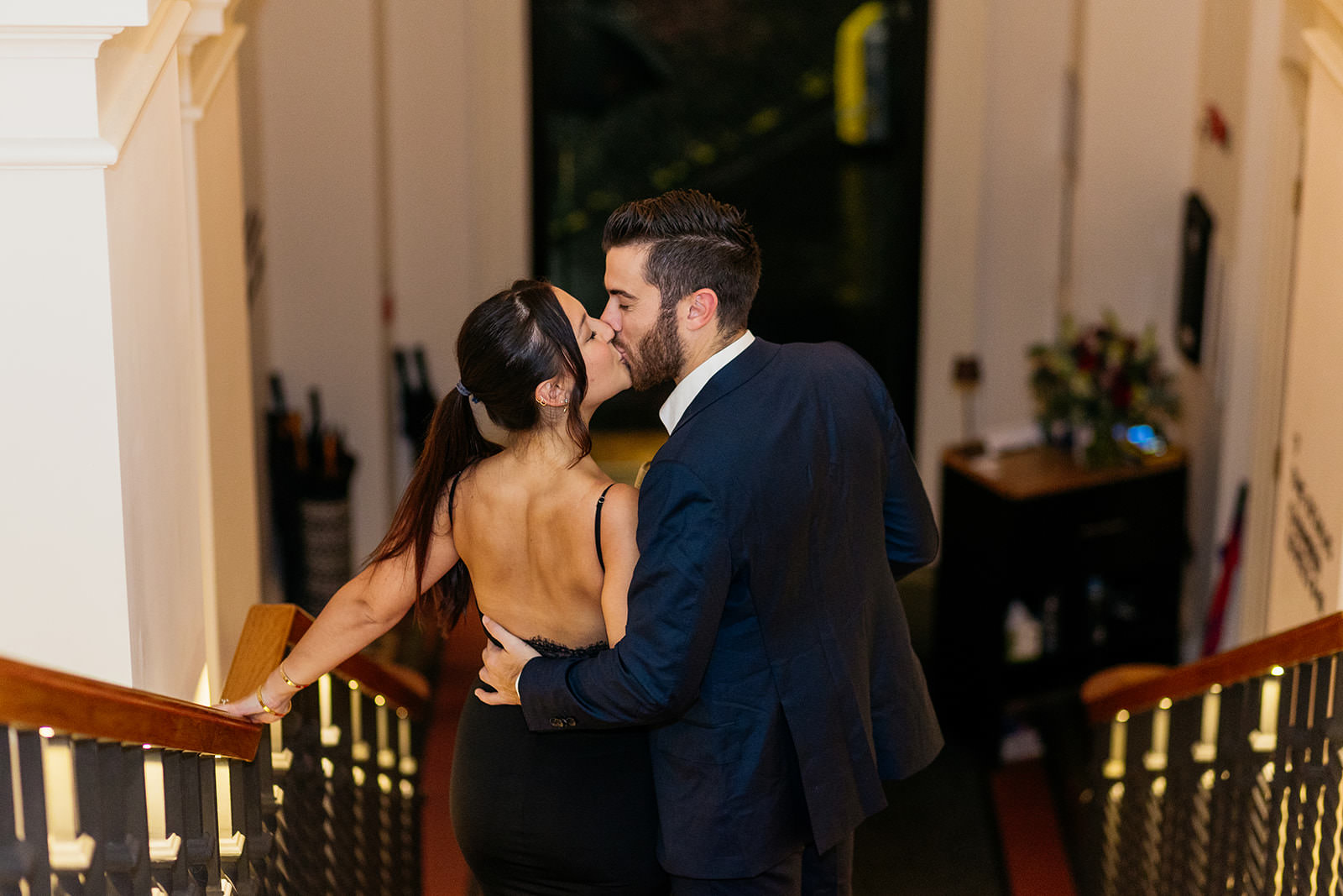couple-stop-to-kiss-as-they-walk-down-the-staircase-in-the-virgin-hotel-edinburgh