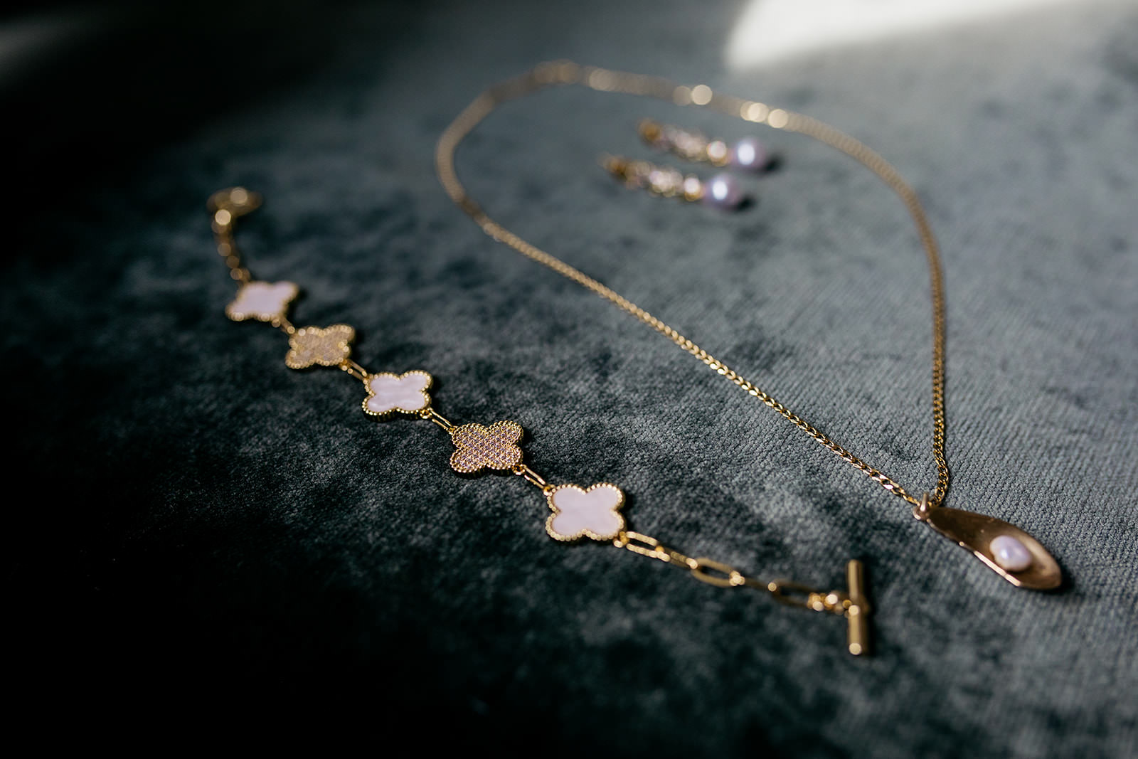 gold bridal jewellery resting on a dark green suede cushion.