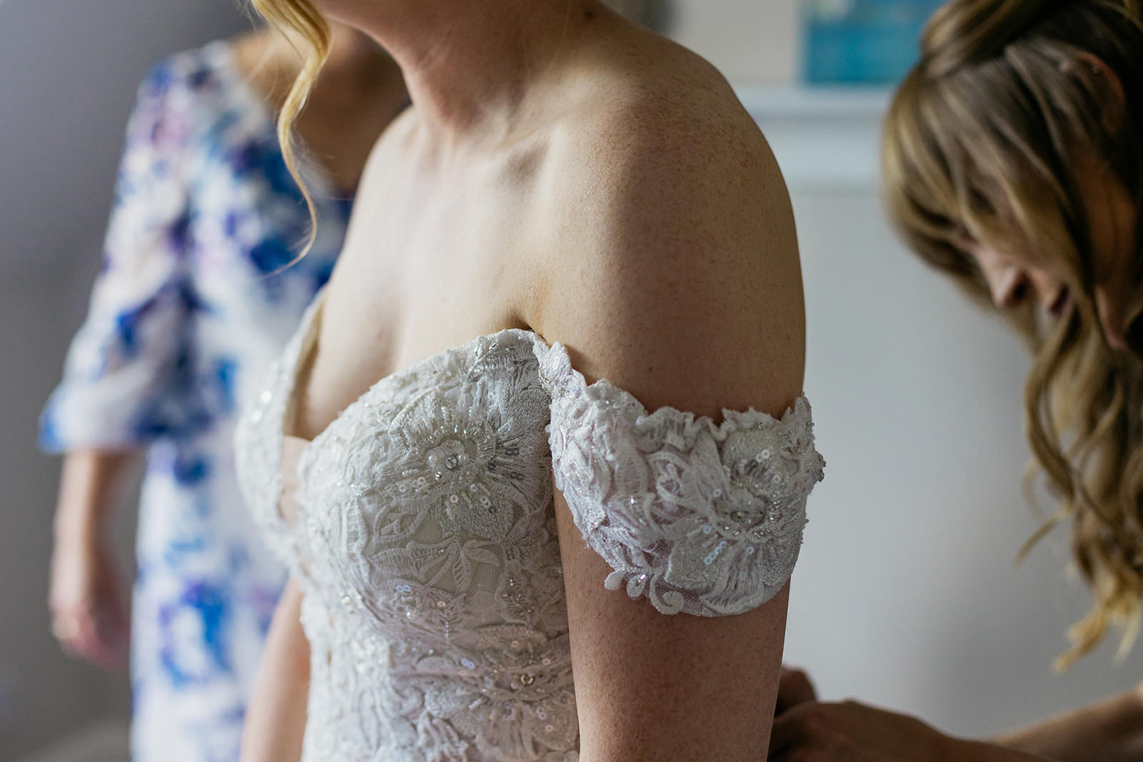 there are small lace sleeves on the dress and they are sitting off the brides shoulder.