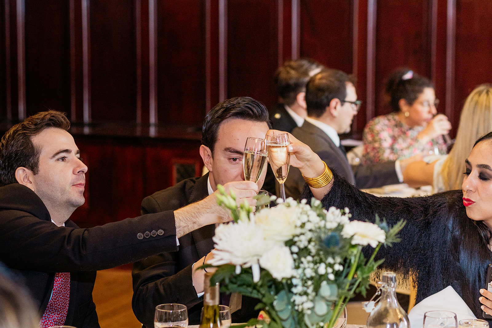 guests are clinking their glasses together during a speech at the Trades Hall.