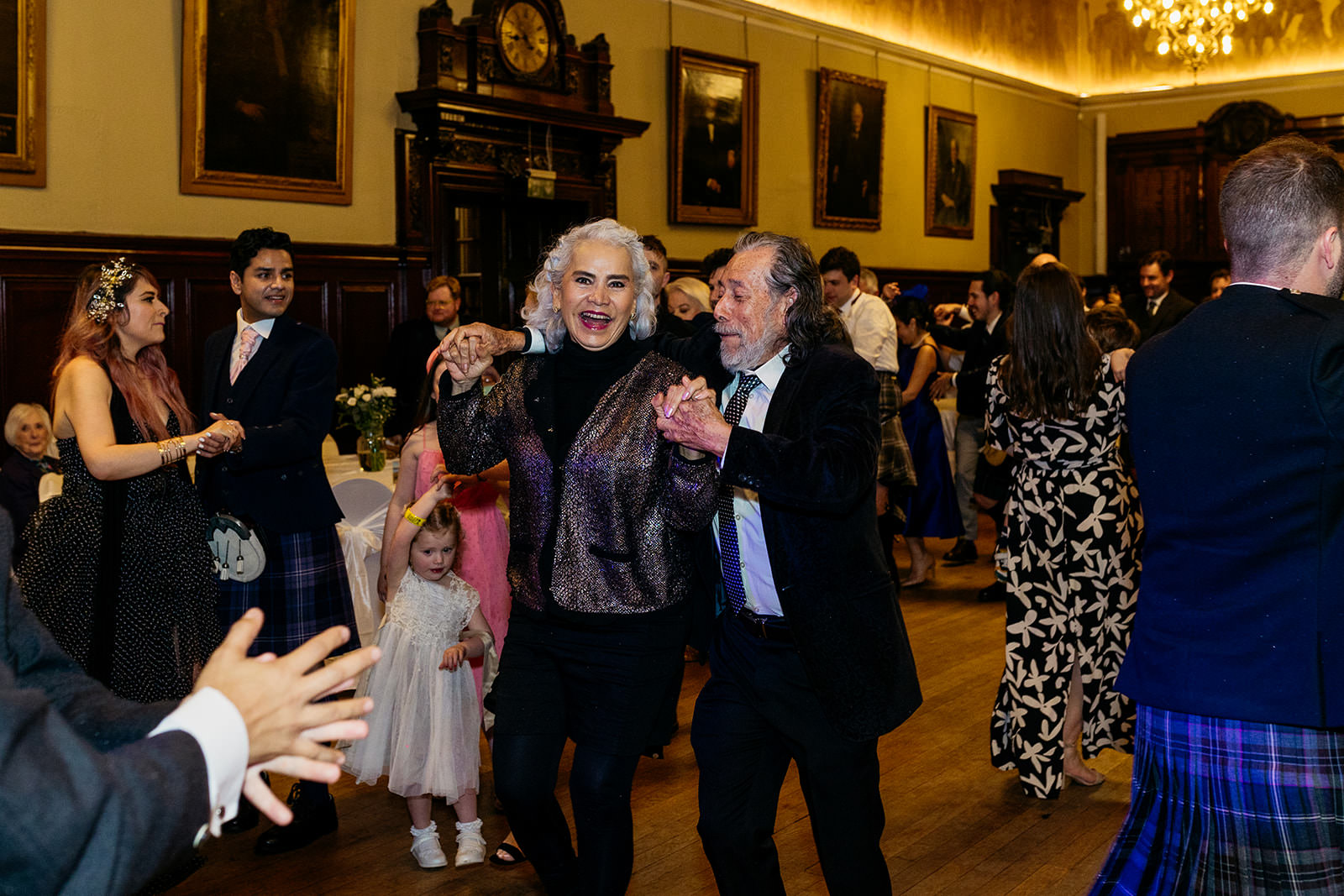 a couple are dancing the gay gordons at a wedding.