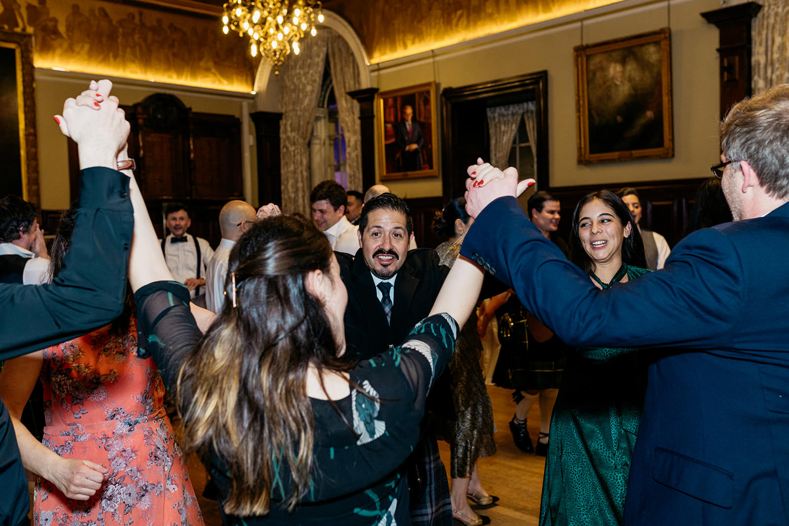 guests are ceilidh dancing at a wedding reception at the Trades Hall in Glasgow city centre.