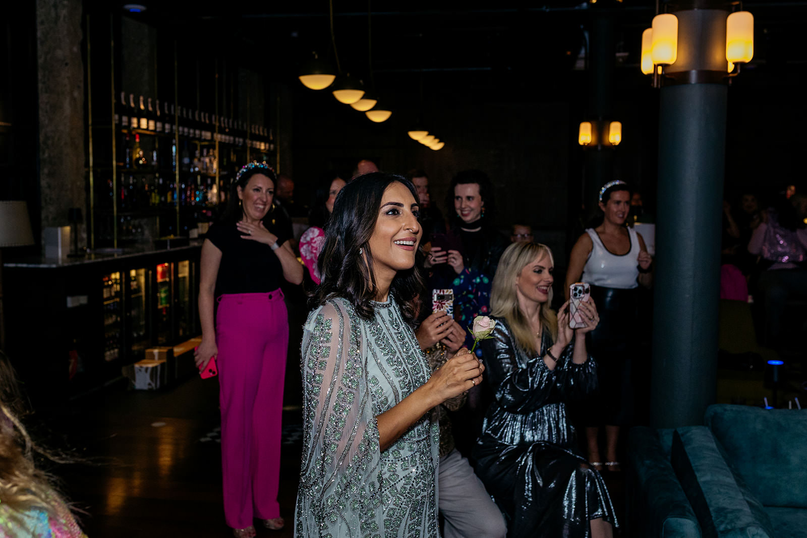 Dr. Punam is smiling and she is surrounded by her friends and family.