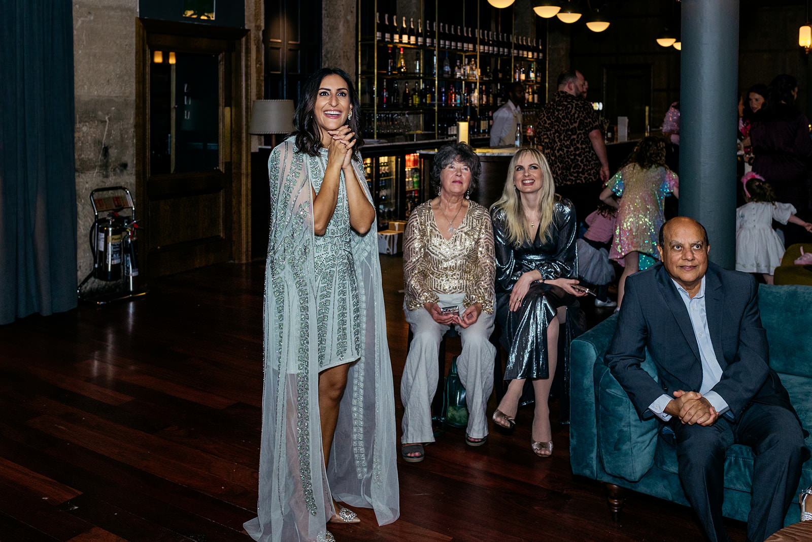 Dr. Punam is smiling and she is surrounded by her friends and family.