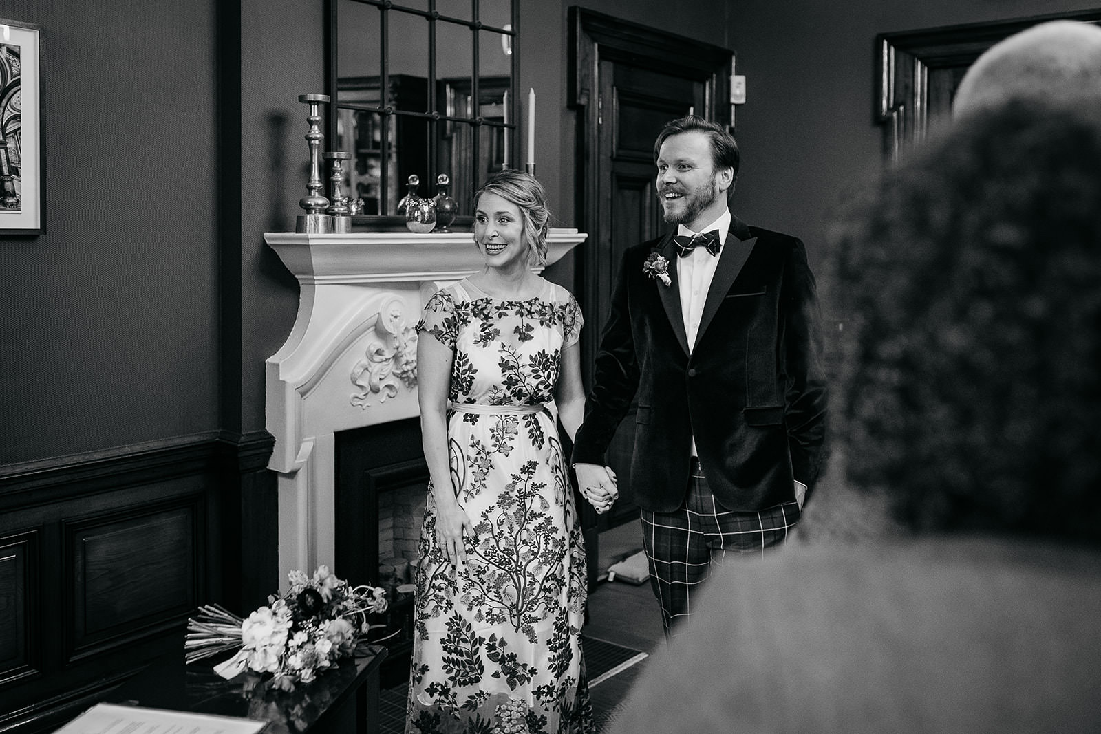 a bride and groom are standing side by side in the ceremony room at 23 montrose street, Glasgow. They are holding hands.