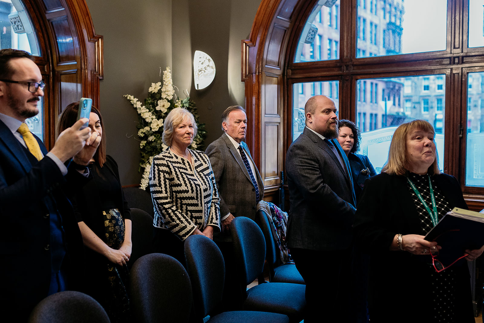 wedding guests are standing in the ceremony room at montrose street in glasgow city chambers